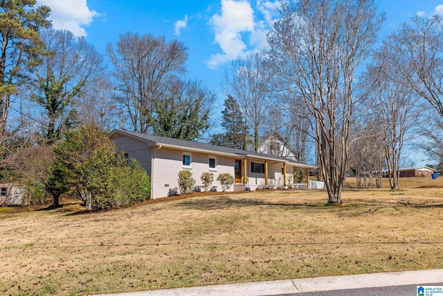 ranch-style home featuring a front lawn, brick siding, covered porch, and crawl space