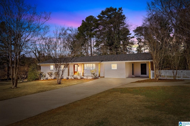 single story home featuring a front yard, concrete driveway, and fence