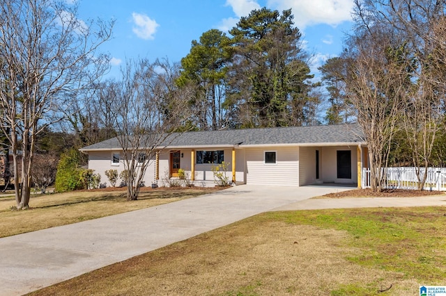 ranch-style house featuring driveway, a front yard, and fence