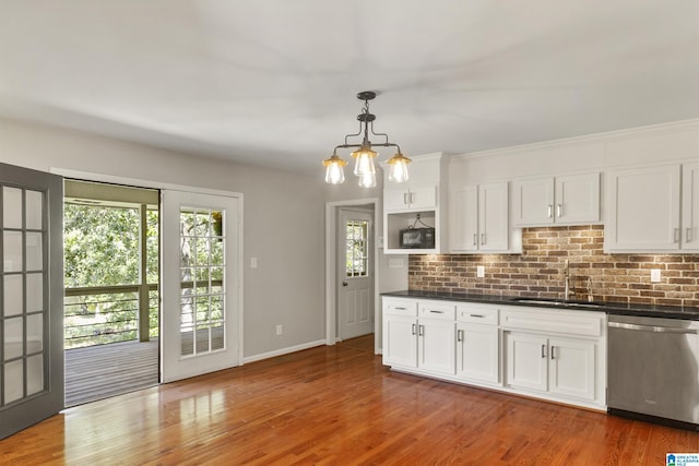 kitchen featuring dark countertops, light wood finished floors, dishwasher, white cabinetry, and a sink