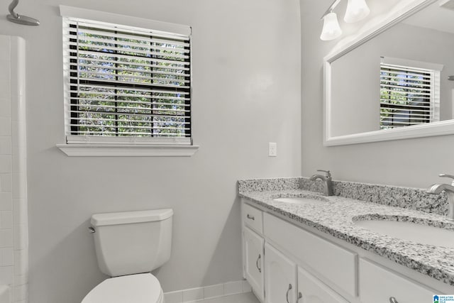 full bathroom with double vanity, toilet, baseboards, and a sink