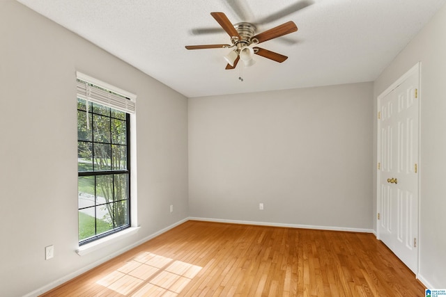 unfurnished room with light wood finished floors, plenty of natural light, and baseboards