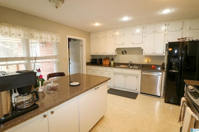 kitchen with light floors, recessed lighting, a sink, stainless steel appliances, and white cabinetry