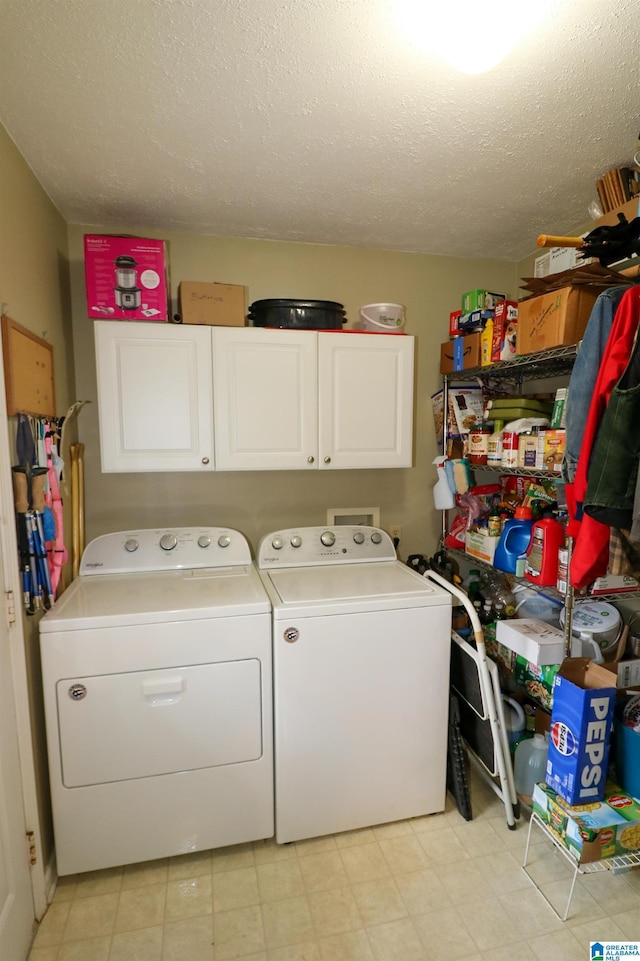 washroom featuring a textured ceiling, cabinet space, light floors, and washer and clothes dryer