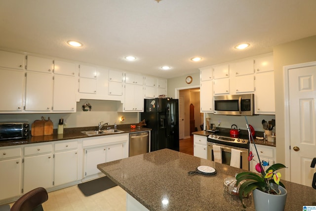 kitchen with a sink, appliances with stainless steel finishes, white cabinets, and recessed lighting