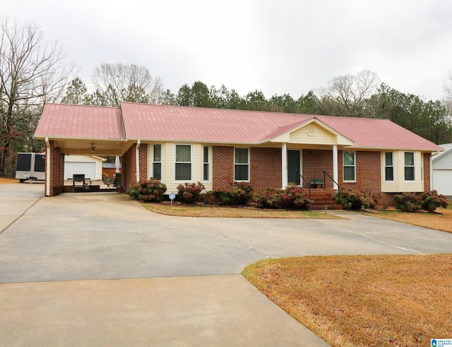 ranch-style house featuring an attached carport, concrete driveway, brick siding, and metal roof