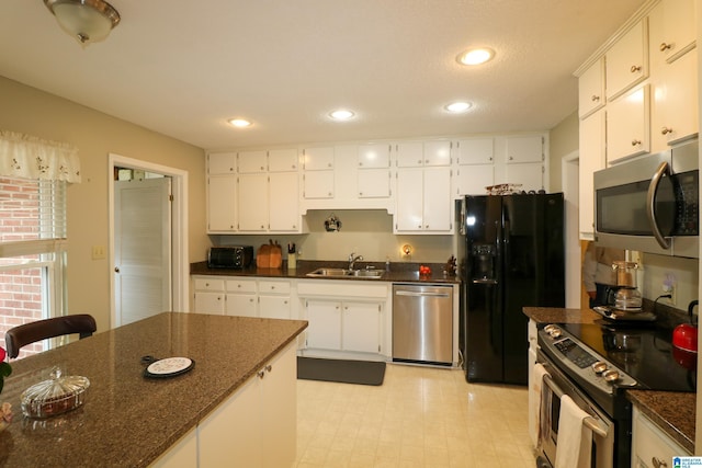 kitchen featuring a sink, stainless steel appliances, white cabinets, and recessed lighting