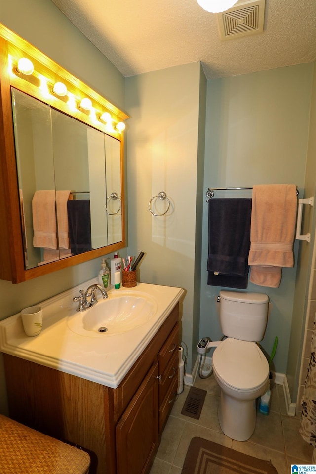 bathroom featuring tile patterned flooring, visible vents, toilet, vanity, and a textured ceiling