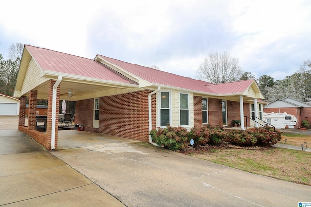 view of property exterior featuring brick siding, an attached carport, metal roof, and an outdoor structure