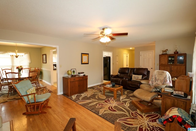 living area with light wood-style flooring, baseboards, and ceiling fan