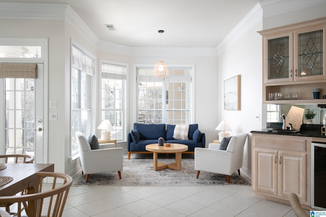 living room featuring wet bar, crown molding, light tile patterned flooring, and visible vents