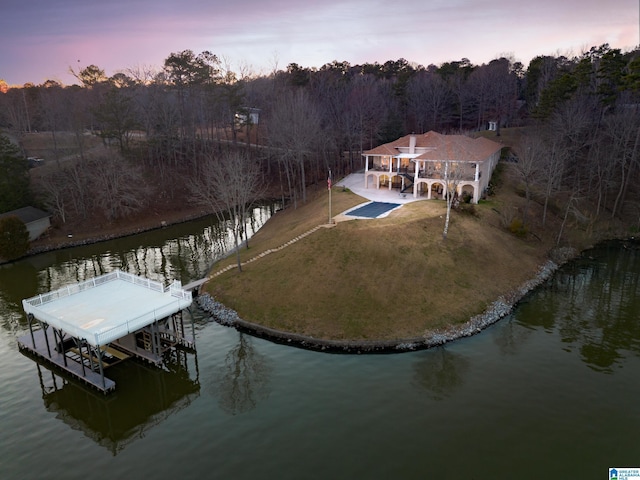 view of dock with a yard, a water view, and boat lift