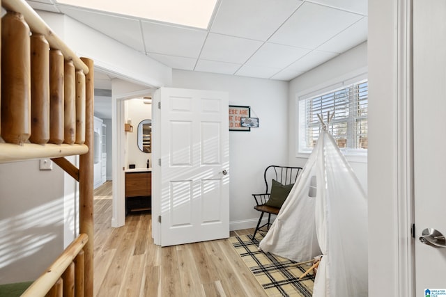 staircase featuring wood finished floors, baseboards, and a drop ceiling