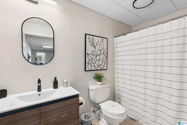 bathroom featuring a shower with shower curtain, vanity, toilet, and a paneled ceiling