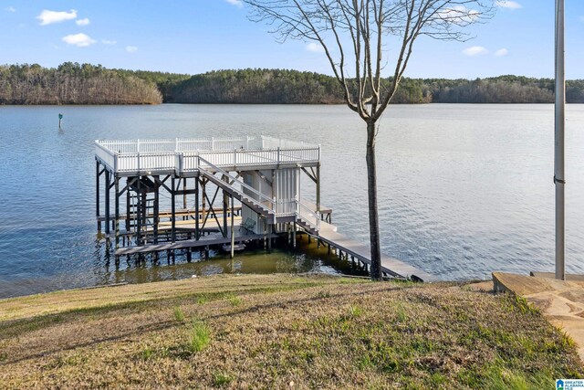 view of dock featuring a water view and a wooded view