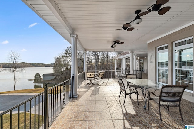 view of patio / terrace featuring outdoor dining space, a ceiling fan, and a water view