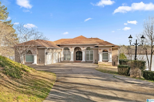 mediterranean / spanish home featuring stucco siding, concrete driveway, and an attached garage