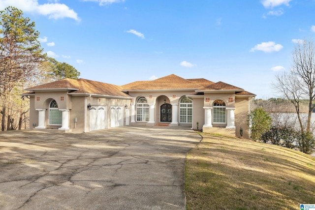 mediterranean / spanish home with stucco siding, driveway, and an attached garage