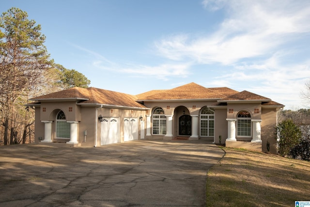 mediterranean / spanish home with a garage and driveway