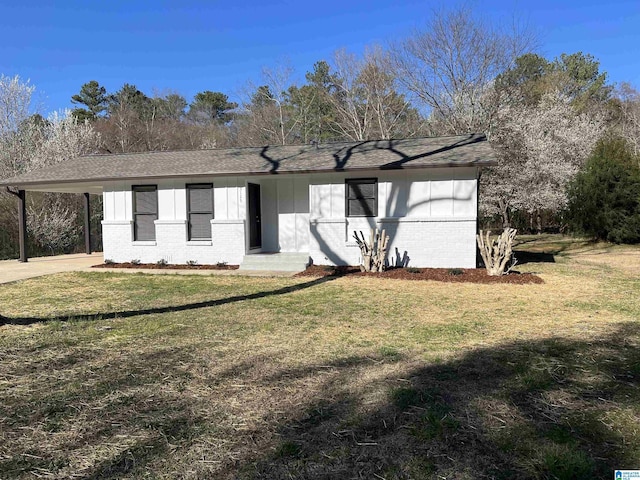 view of front of house featuring a carport, driveway, brick siding, and a front lawn