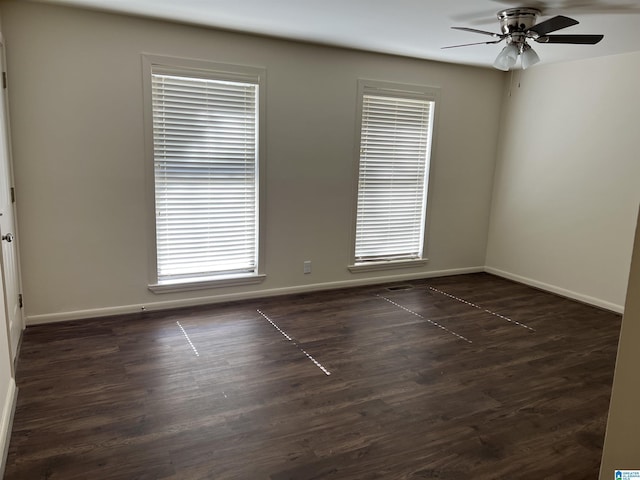 empty room featuring ceiling fan, baseboards, and dark wood-style flooring