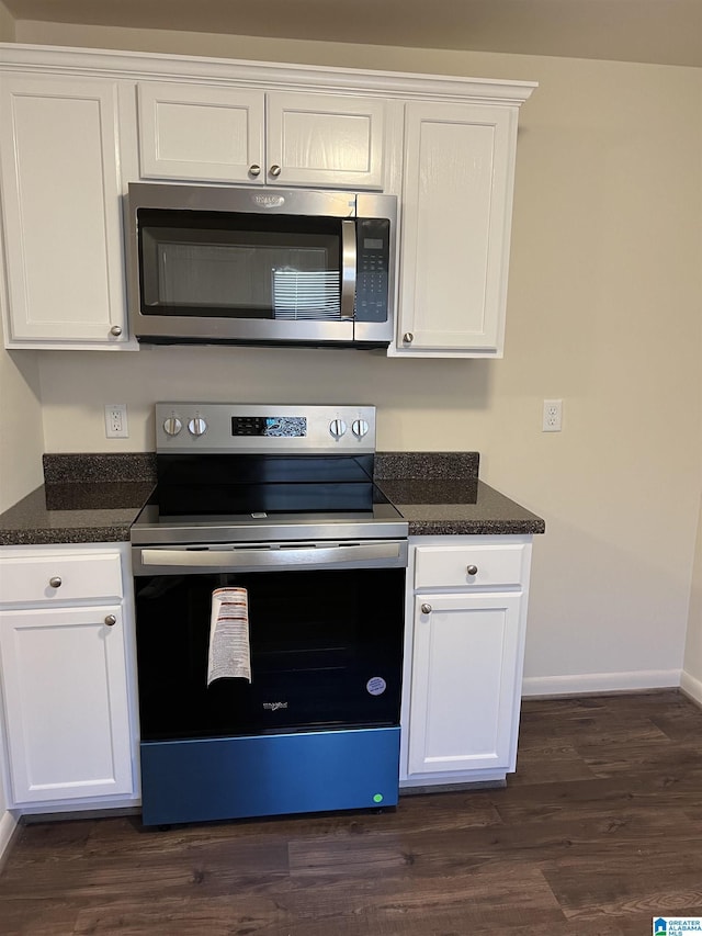 kitchen with white cabinetry, dark wood-style floors, baseboards, and stainless steel appliances