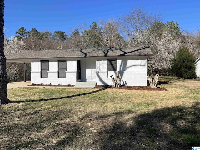 single story home featuring brick siding, a carport, concrete driveway, and a front yard