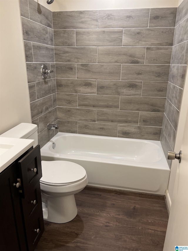 bathroom with bathing tub / shower combination, toilet, wood finished floors, and vanity