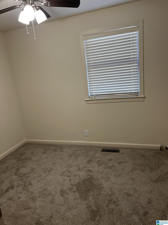 spare room with baseboards, visible vents, carpet floors, and ceiling fan