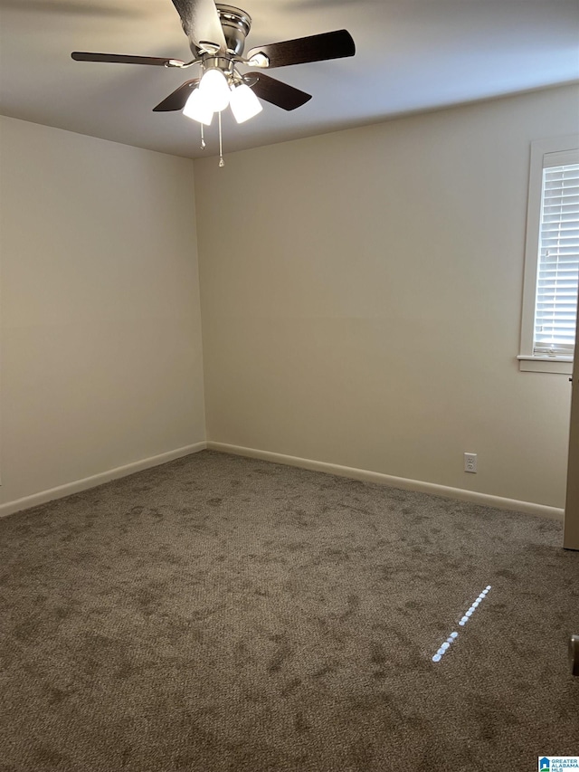 carpeted empty room featuring baseboards and ceiling fan