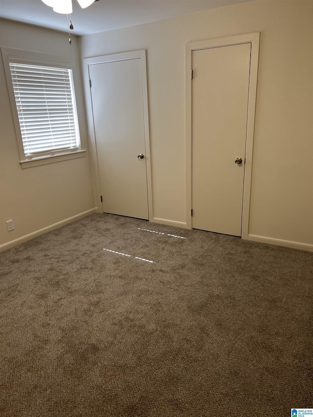 unfurnished bedroom featuring baseboards and carpet