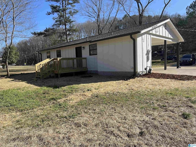 exterior space featuring a carport, board and batten siding, a front lawn, and roof with shingles