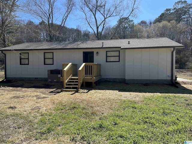 rear view of property with central AC, a yard, board and batten siding, roof with shingles, and crawl space