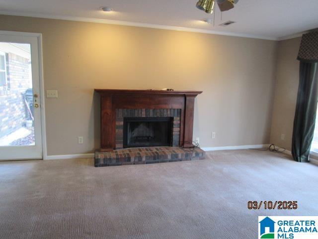 unfurnished living room featuring baseboards, carpet floors, a fireplace, and crown molding