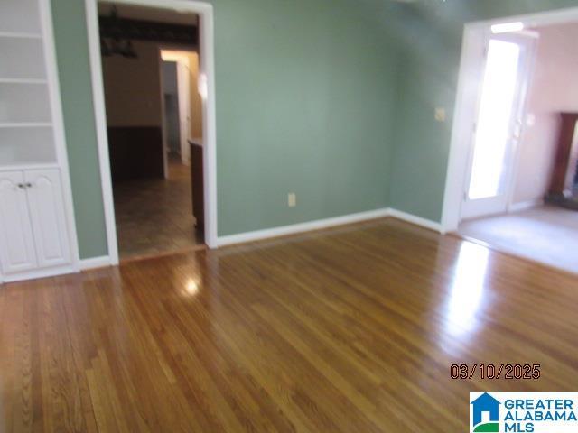 interior space with wood finished floors and baseboards