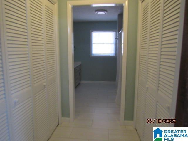 hall with tile patterned floors and baseboards