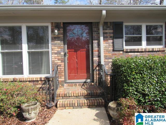 entrance to property featuring brick siding