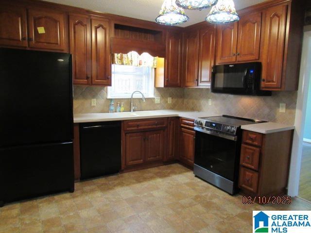 kitchen with tasteful backsplash, black appliances, light countertops, and a sink