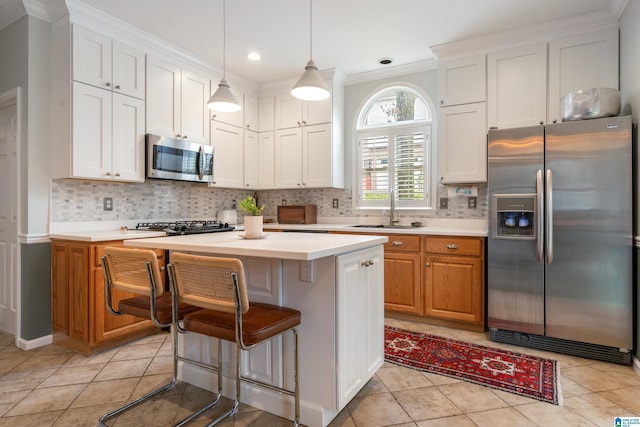 kitchen with a sink, decorative backsplash, light countertops, and stainless steel appliances