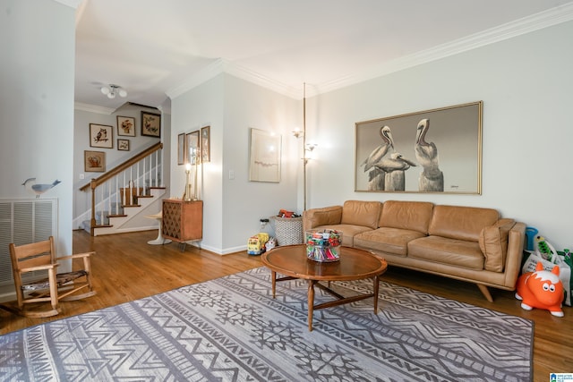 living area featuring baseboards, stairs, ornamental molding, wood finished floors, and heating unit