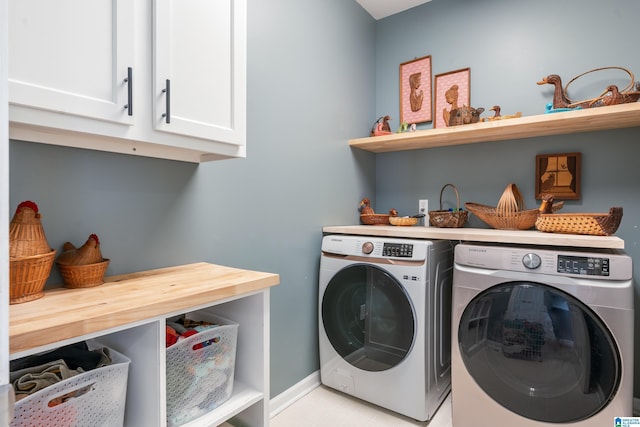 clothes washing area with washer and dryer, cabinet space, and baseboards