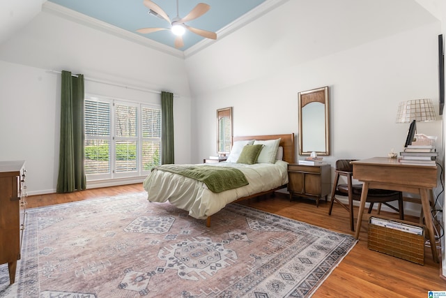 bedroom with ornamental molding, baseboards, ceiling fan, and wood finished floors