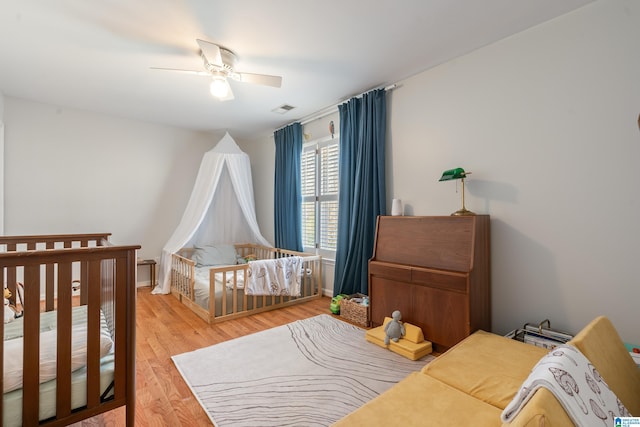 bedroom with visible vents, baseboards, ceiling fan, and light wood finished floors