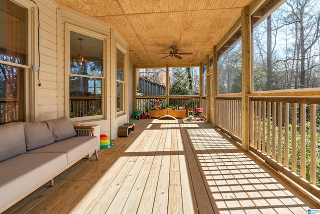 sunroom / solarium featuring wooden ceiling, plenty of natural light, and ceiling fan