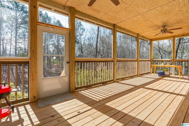 unfurnished sunroom featuring wood ceiling and a ceiling fan