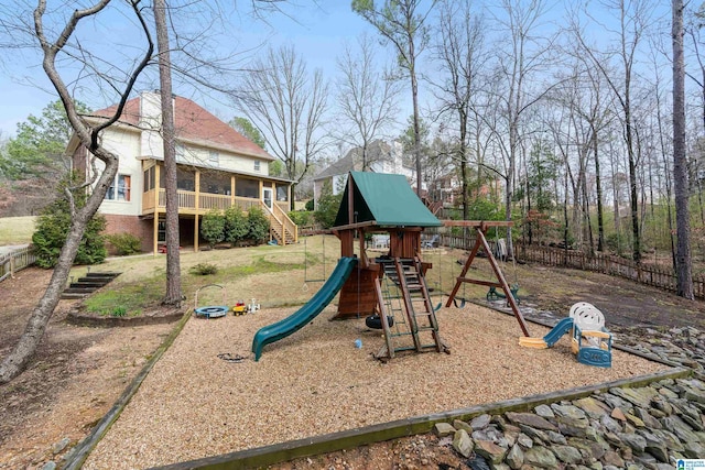 view of jungle gym featuring stairway, fence, and a sunroom