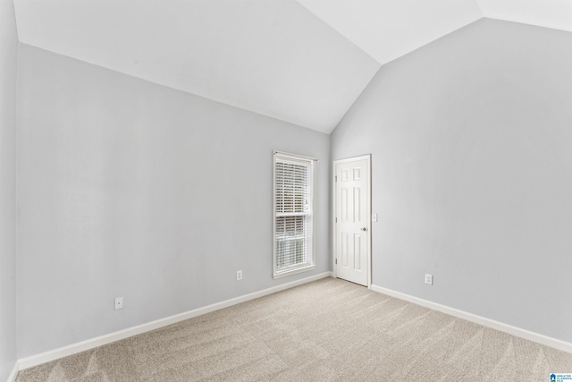 unfurnished room with baseboards, carpet, and vaulted ceiling