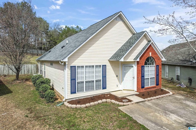 view of front of property with a front lawn, fence, and a shingled roof