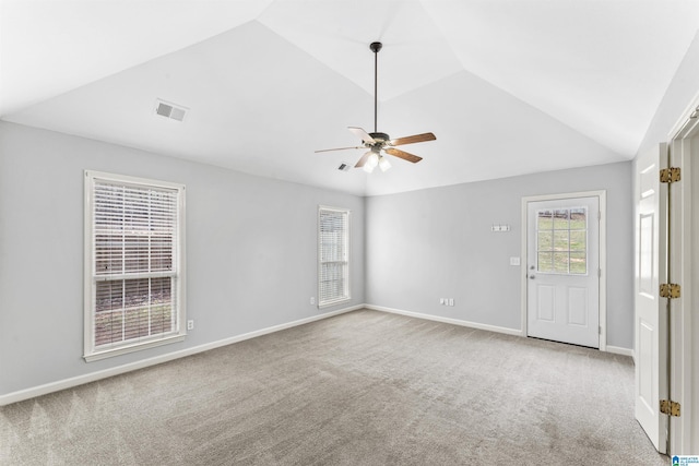 carpeted empty room featuring visible vents, baseboards, lofted ceiling, and a ceiling fan