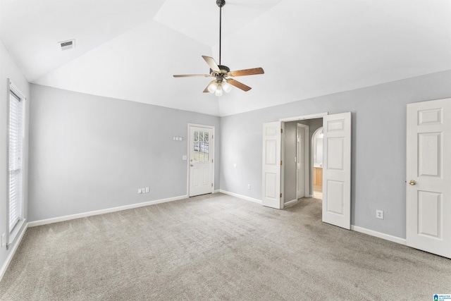 unfurnished bedroom with lofted ceiling, multiple windows, visible vents, and carpet floors